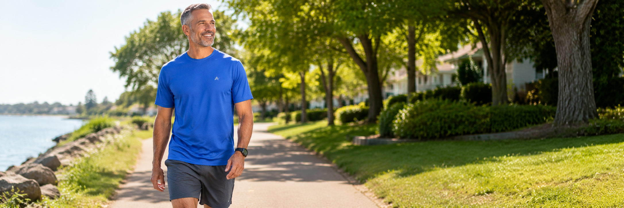 Man wearing an Arctic Cool cooling shirt while walking on a sunny outdoor path in hot weather